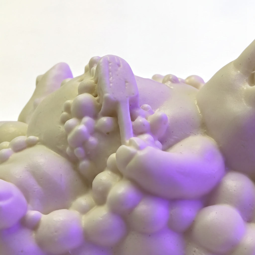 A close-up view of a white, foamy substance with a small object resembling a toothbrush or similar item in the center.