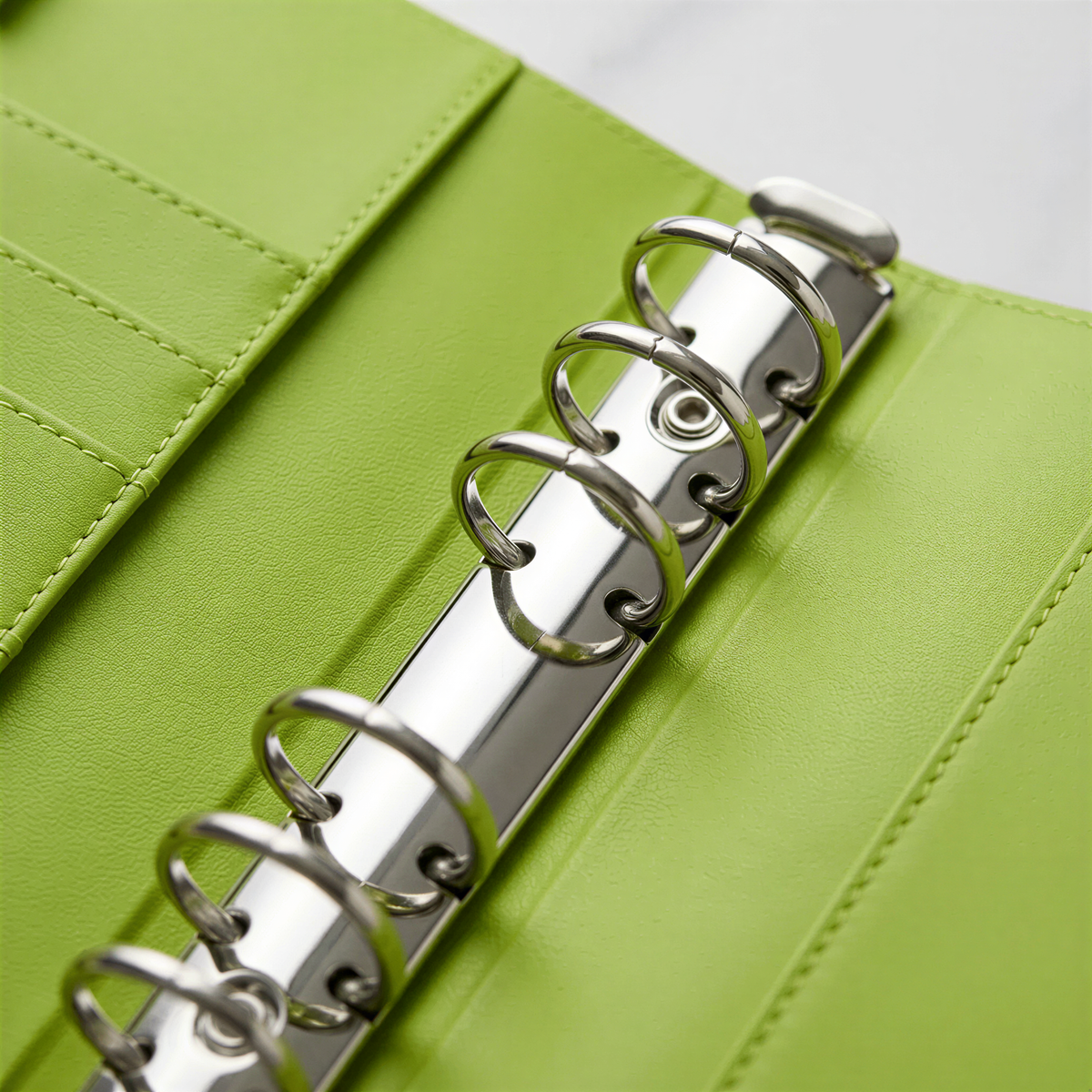 A close-up view of a spiral-bound notebook with a green cover, showcasing the spiral binding mechanism.