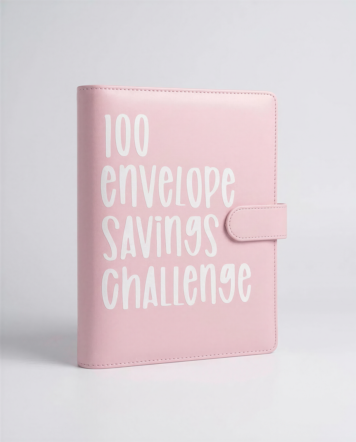 A pink leather-bound notebook or planner with the text "100 envelope savings challenge" printed on it.