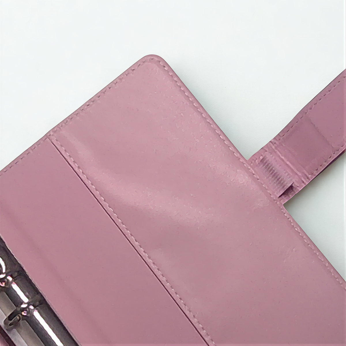 Pink leather wallet with visible stitching and textured surface