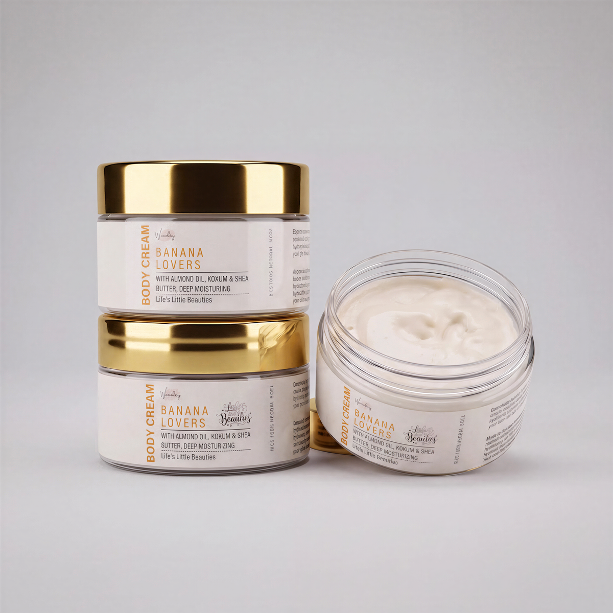 three jars of Banana Cream body cream, each with a gold lid and white label.