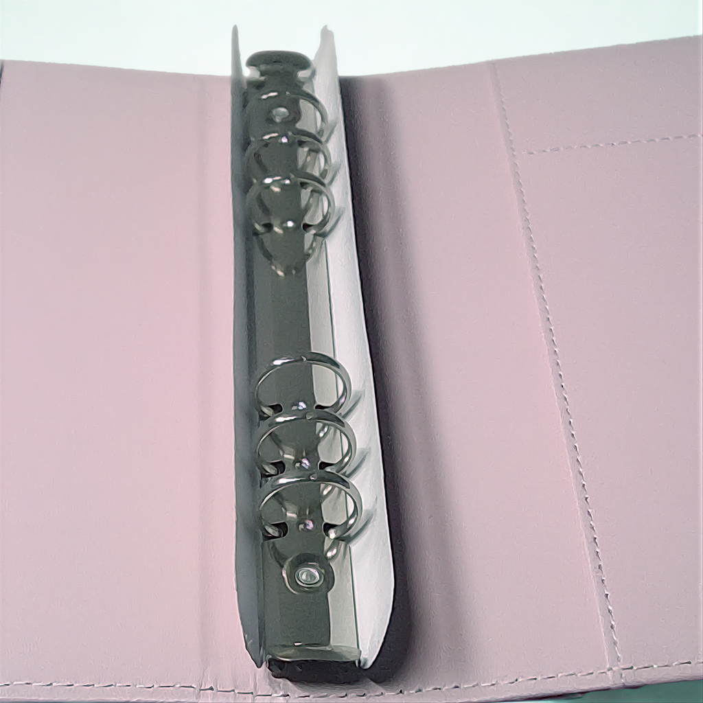 Silver decorative binder clip on textured pink surface