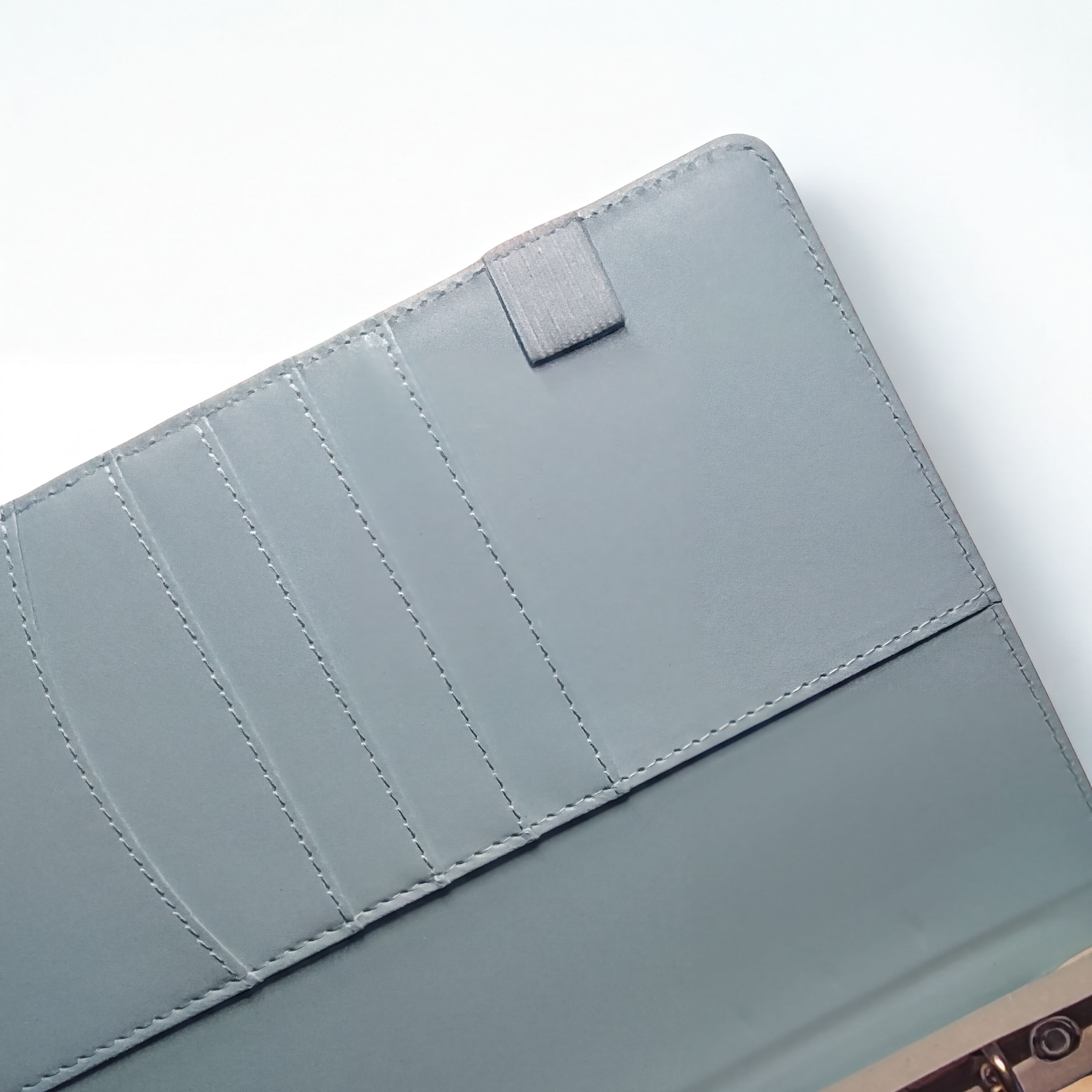 Gray leather wallet interior with card slots and stitching detail
