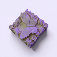 A decorative soap with a butterfly design on it.