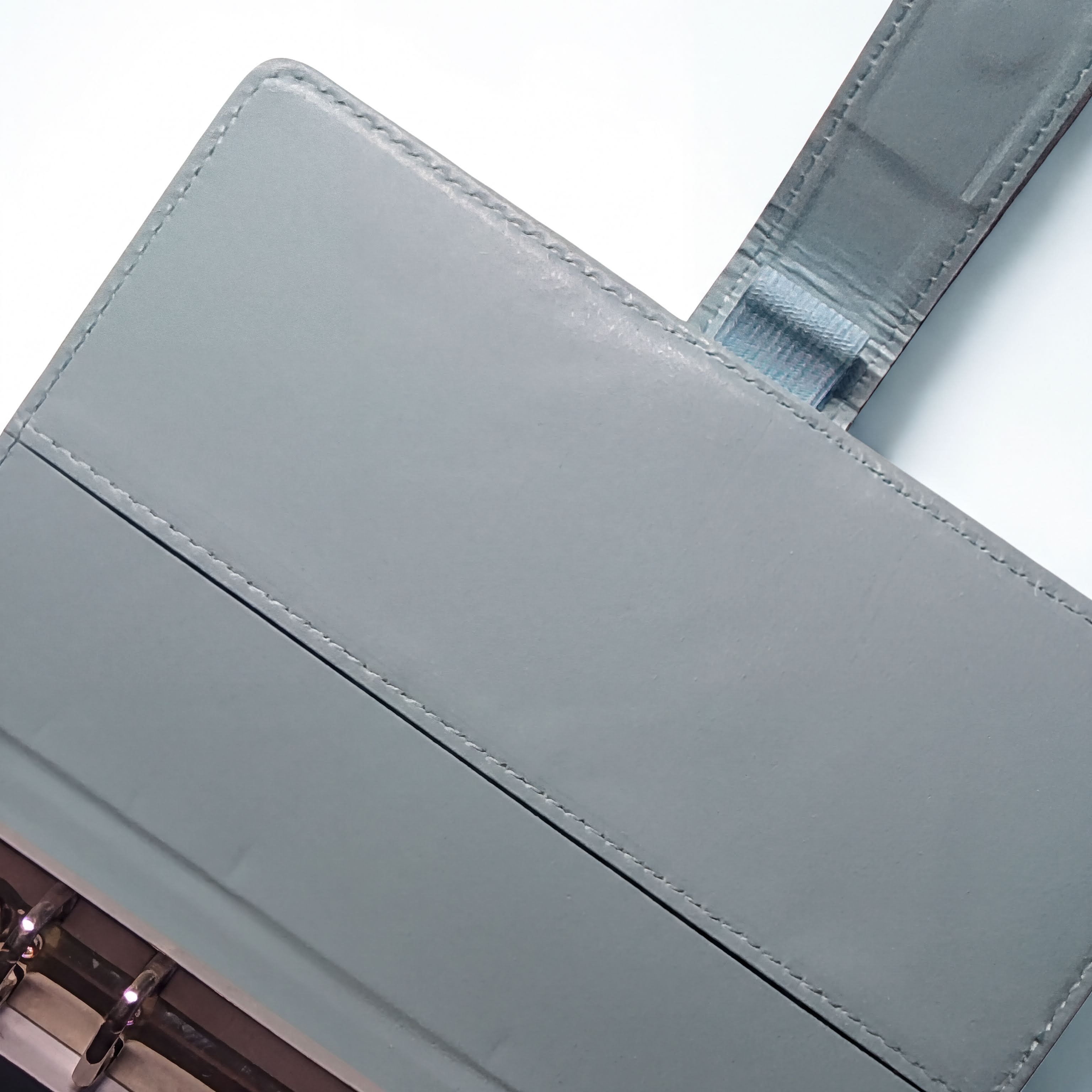 Gray leather wallet with precise stitching and metal hardware details