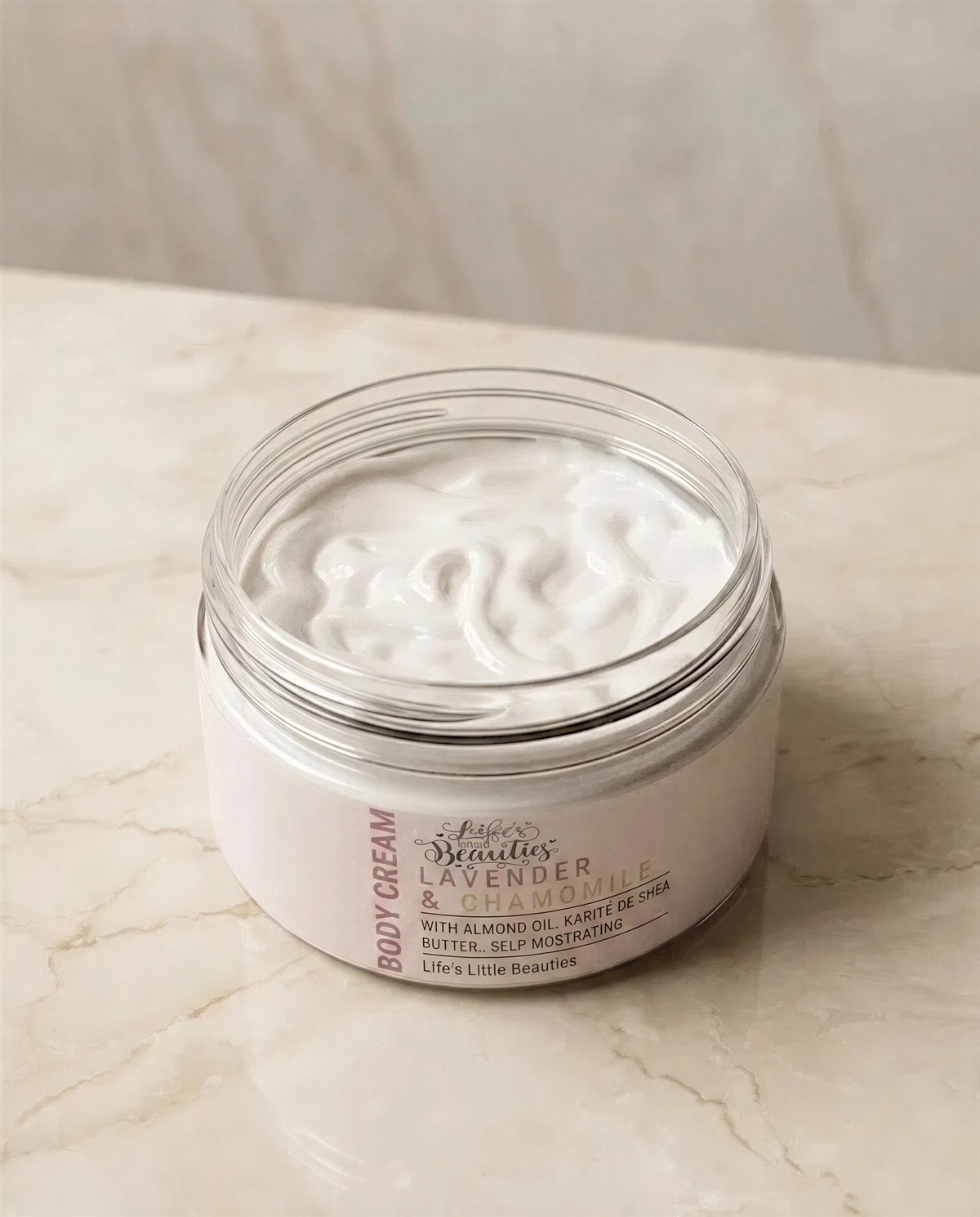 A jar of body cream with a white label that reads "Lush Studio Lender's Lavender & Almond Karmel" and "With Almond Oil Karmel Shea Butter Self-Moisturizing".