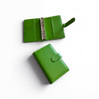 Two green leather wallets are shown on a white background.
