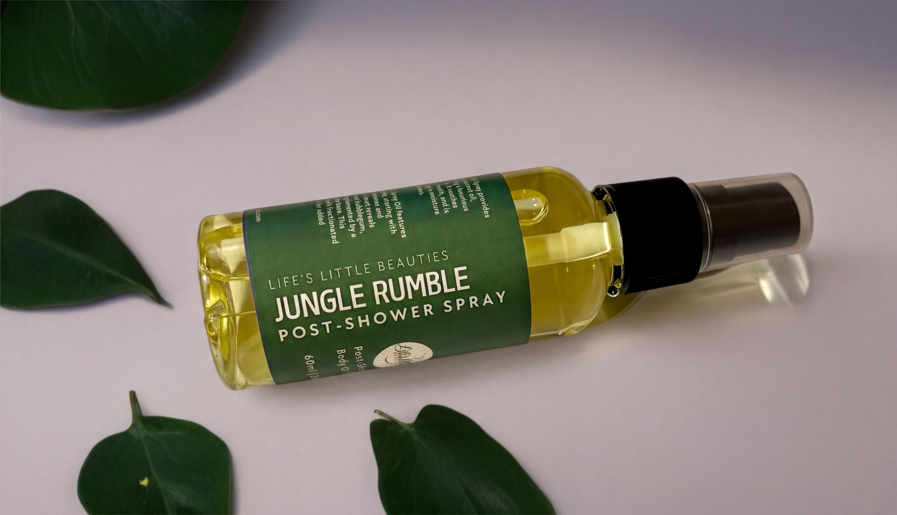 A bottle of Jungle Rumble Post-Shower Spray surrounded by green leaves on a white background.