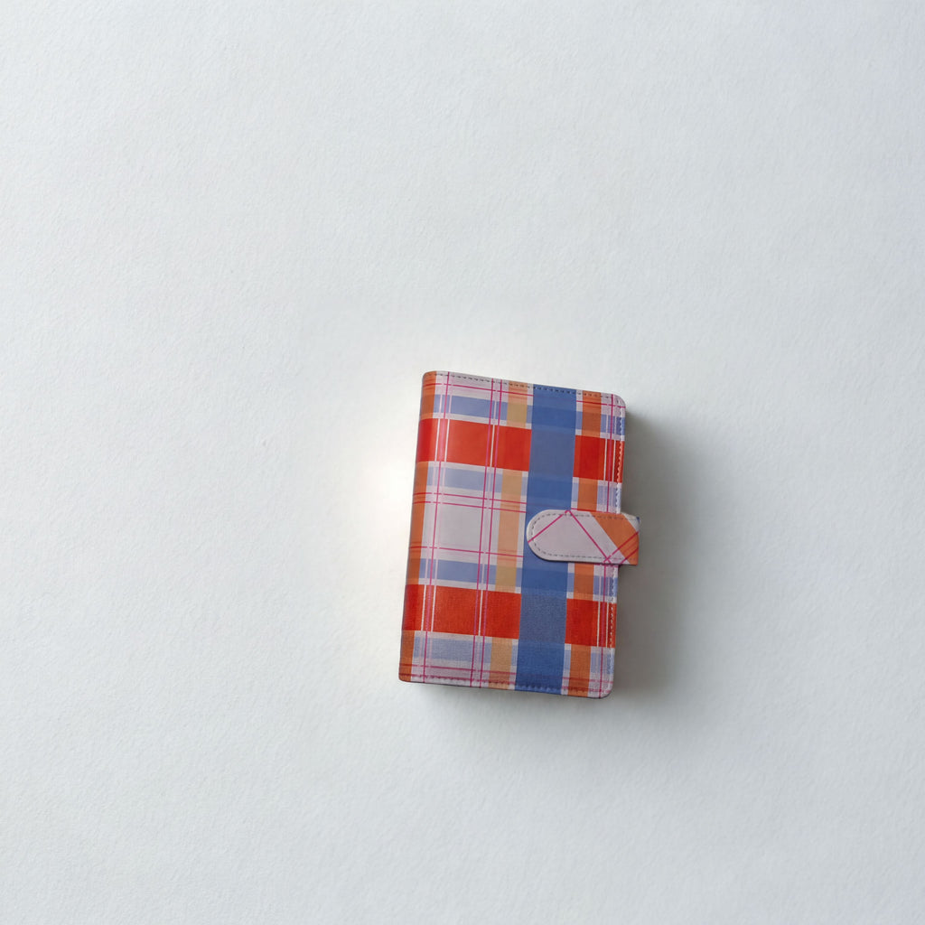 Plaid patterned wallet with orange, blue, and white check design on white background