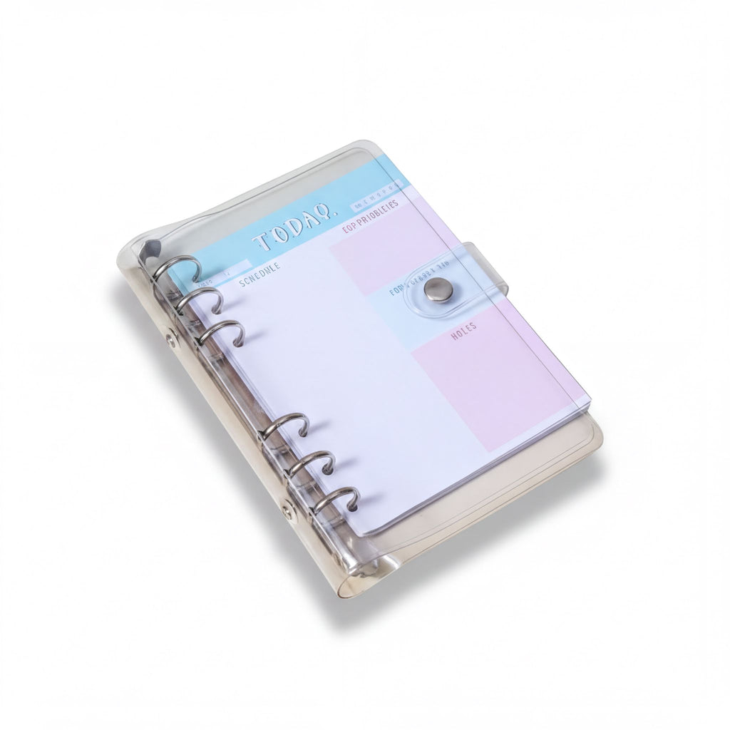a clear, spiral-bound notebook with a pink and blue cover, sitting on a white surface.