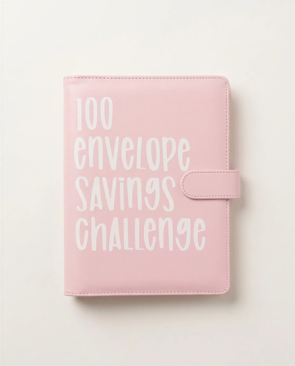 A pink leather-bound notebook or planner with the text "100 envelope savings challenge" printed on it.