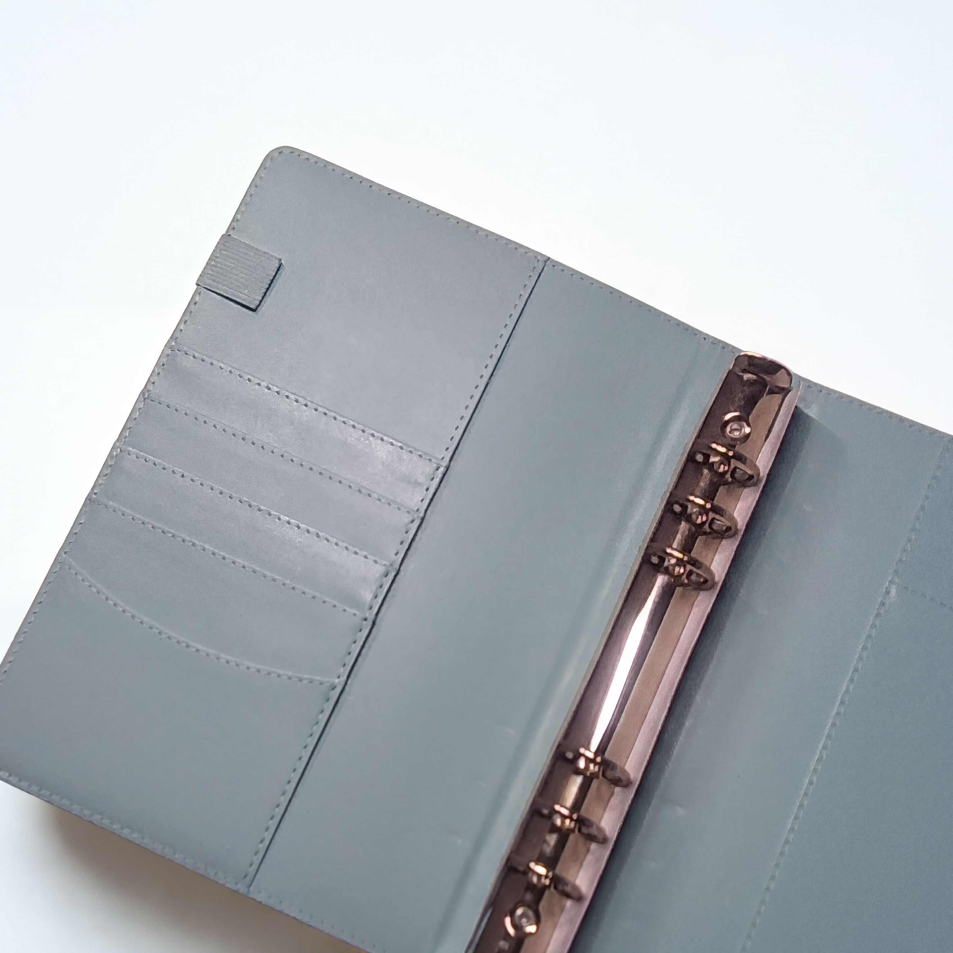 Gray leather planner with card slots and rose gold rings, minimalist design