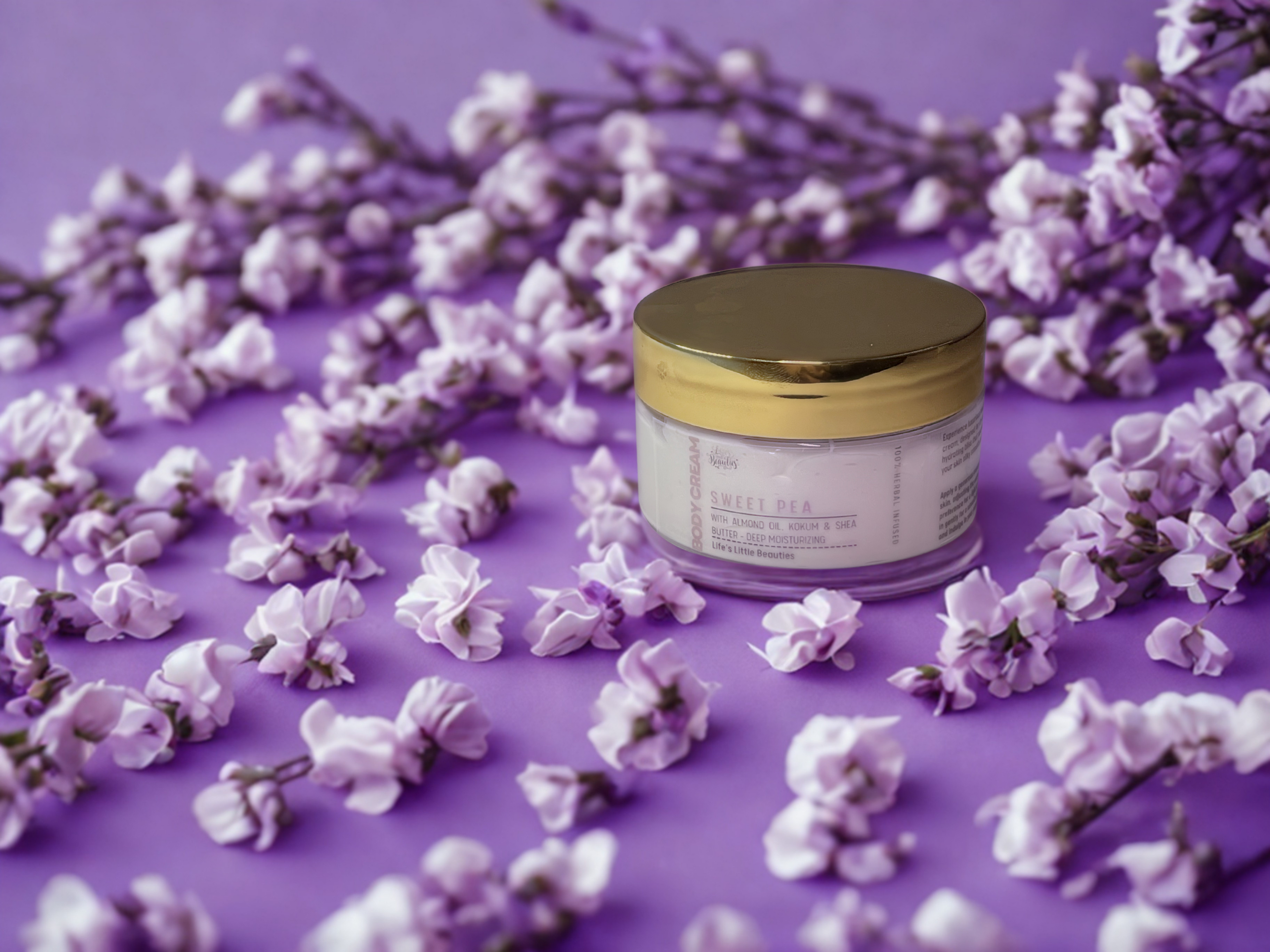 A jar of lotion surrounded by delicate purple flowers on a purple background.