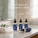 three bottles of The Omega The Omega lotion and spray, placed on a bathroom counter with a towel and a plant. The text above the bottles reads 