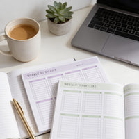 a desk with a laptop, a coffee cup, a potted succulent plant, and two planners or notebooks.
