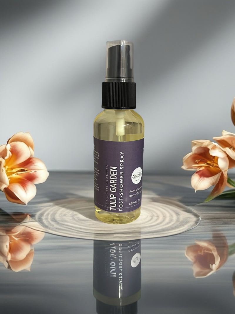 Tulip Garden post-shower body oil spray with natural ingredients, surrounded by fresh flowers on reflective surface
