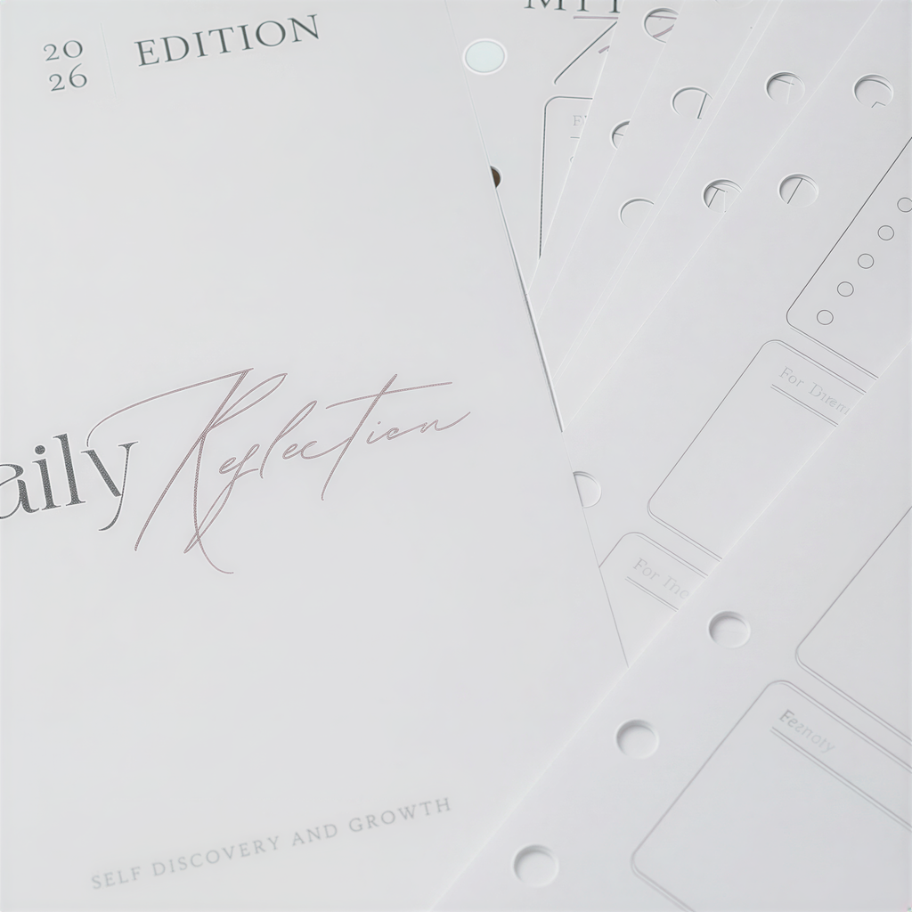 a collection of planners and notebooks, with the focus on a notebook titled "Daily Reflection".