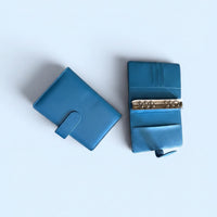 Two blue leather wallets are shown against a light blue background.