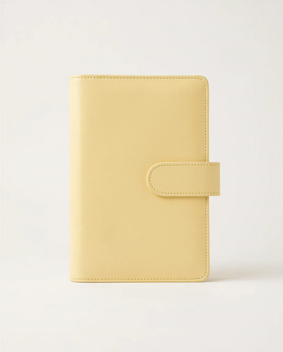 A simple, rectangular yellow leather wallet or book cover against a plain white background.