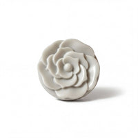 A white, round, flower-shaped object is shown against a white background.
