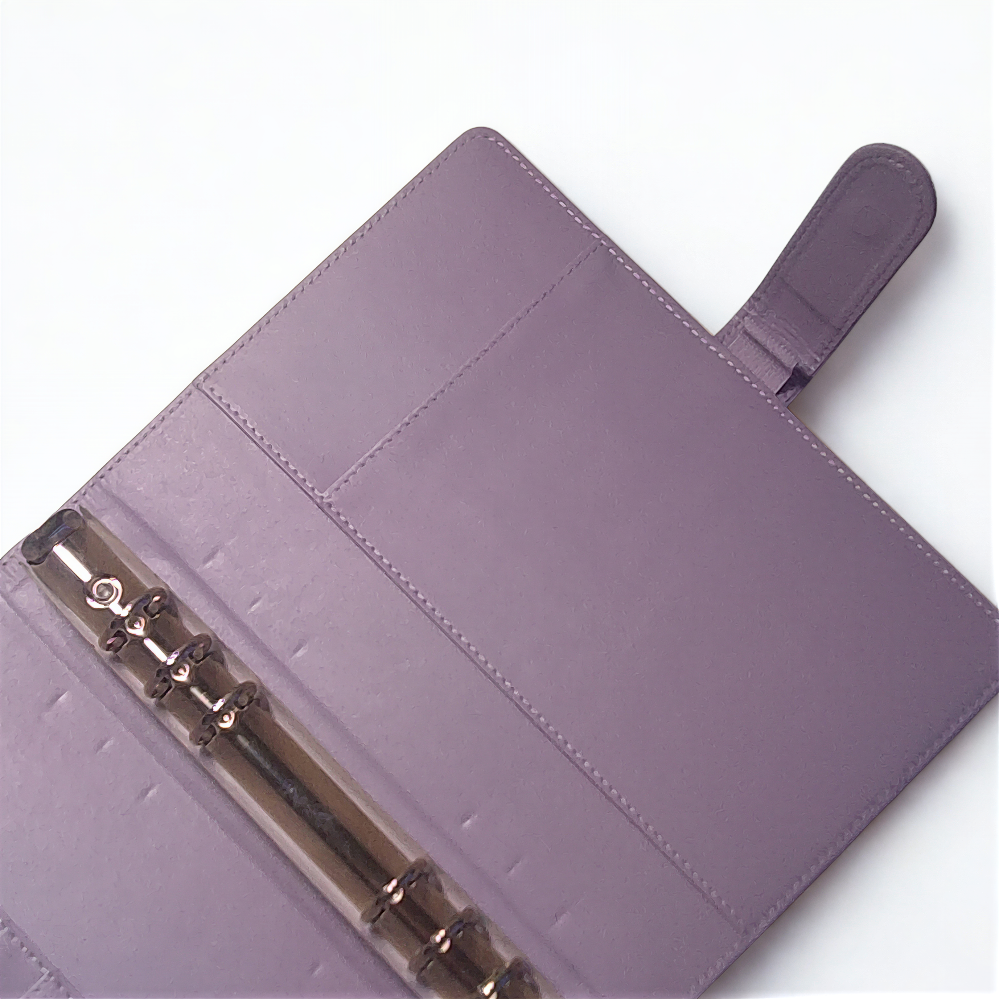 A purple leather-bound notebook with a metal ring and a small hole on the cover.
