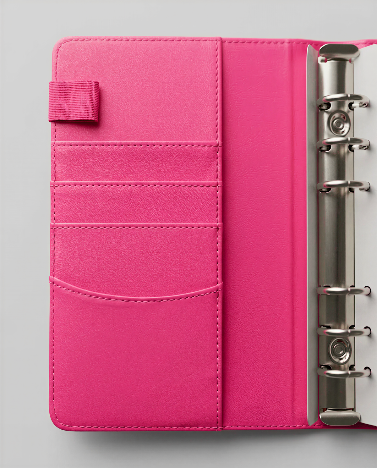 A pink leather-like wallet or binder with a metal ring on the right side.