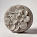 A round, gray soap dish with a floral design featuring multiple flower-shaped soap bubbles.