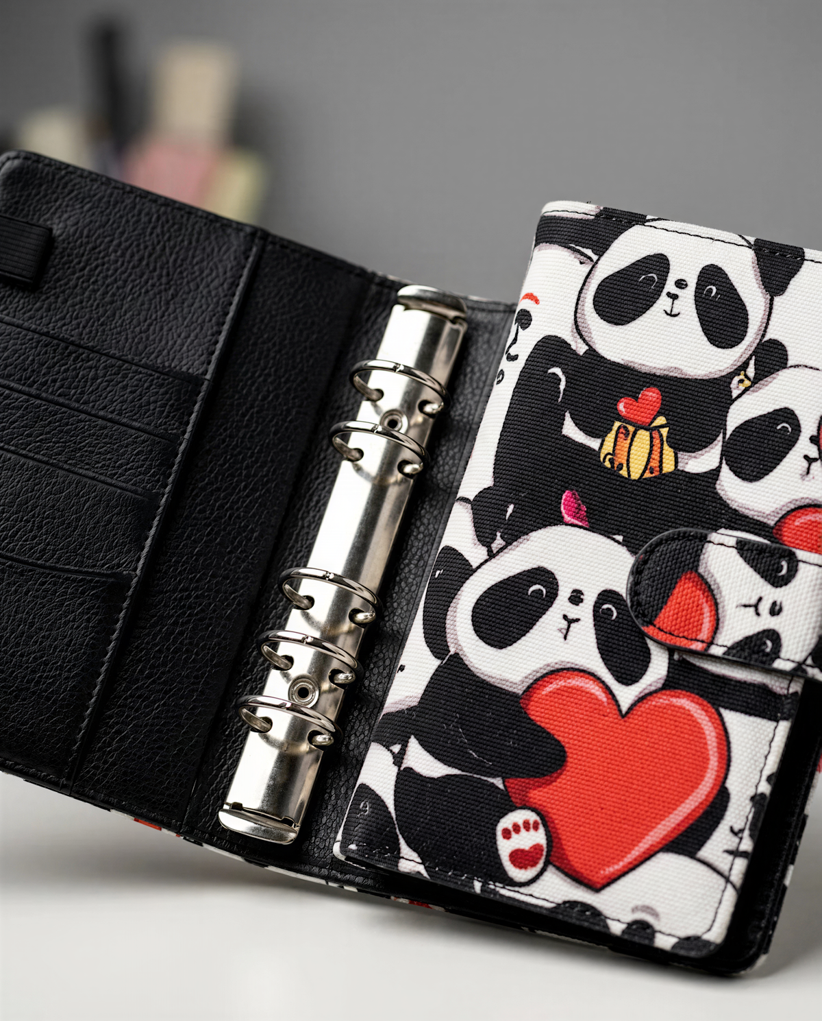 A black leather wallet with a panda-themed design, featuring a red heart and a panda holding a gift.