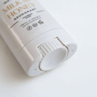A close-up view of a white deodorant can with text and symbols on it.