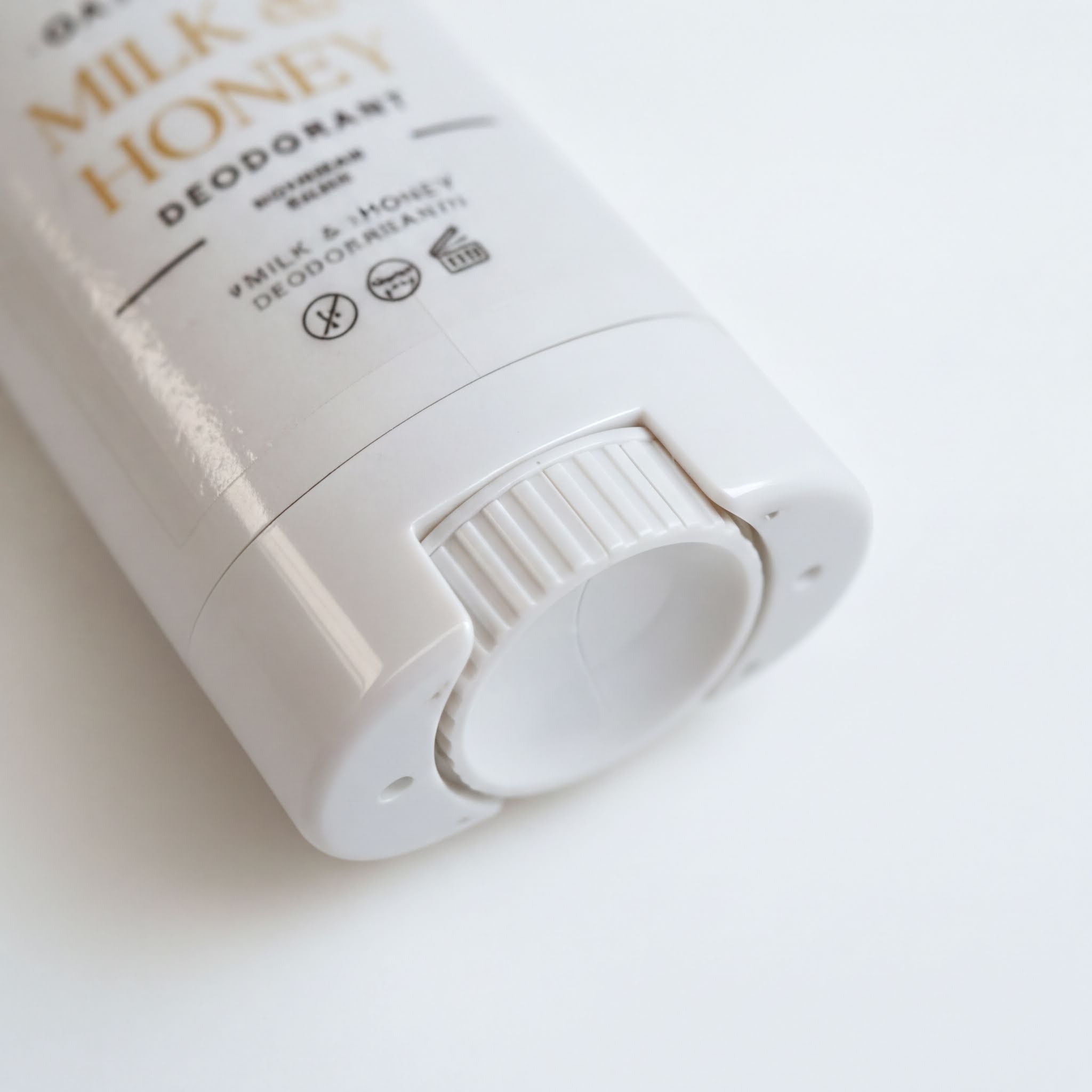A close-up view of a white deodorant can with text and symbols on it.