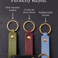 three leather keychains with different colors and designs, each with a gold-colored ring and a black-colored leather strap.