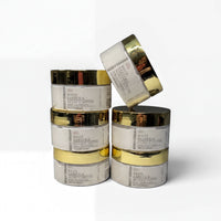 A stack of six jars of "White Gardenia" skincare product, with gold-colored lids, against a white background.