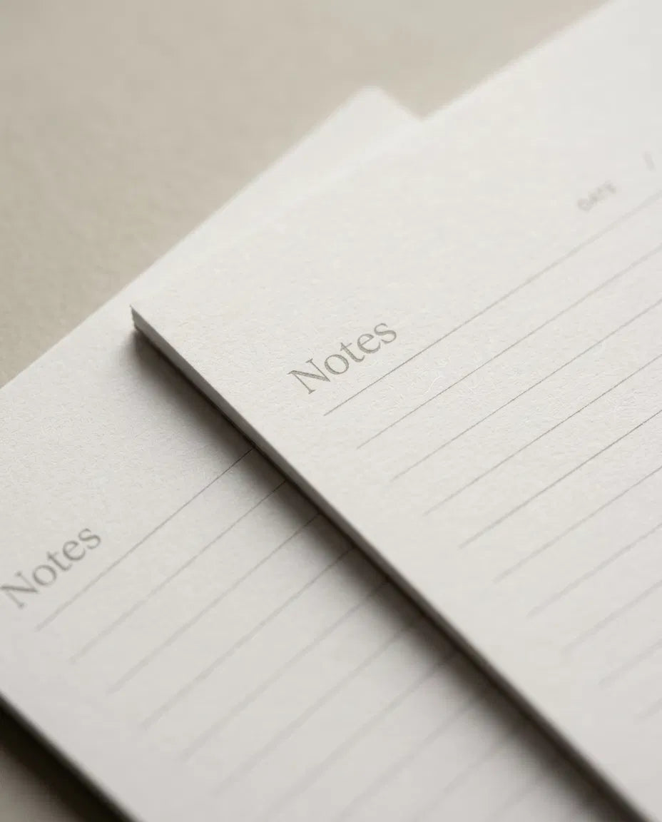 two lined paper pads with the word "Notes" written on them.