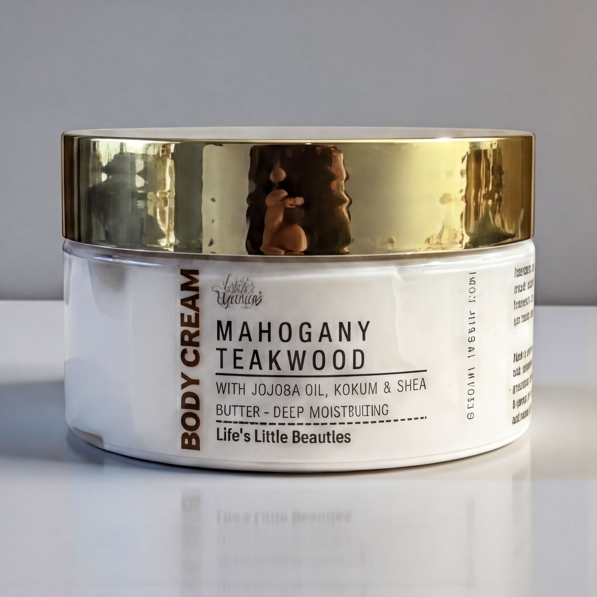 A jar of Mahogany Teakwood body cream with jojoba oil, kokum, and shea butter, with a gold lid.