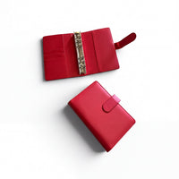 two red leather wallets or binder clips placed on a white background.