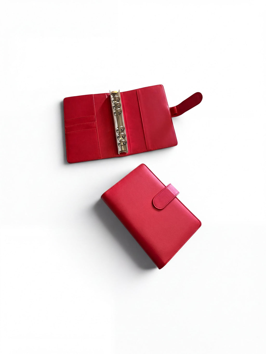 two red leather wallets or binder clips placed on a white background.