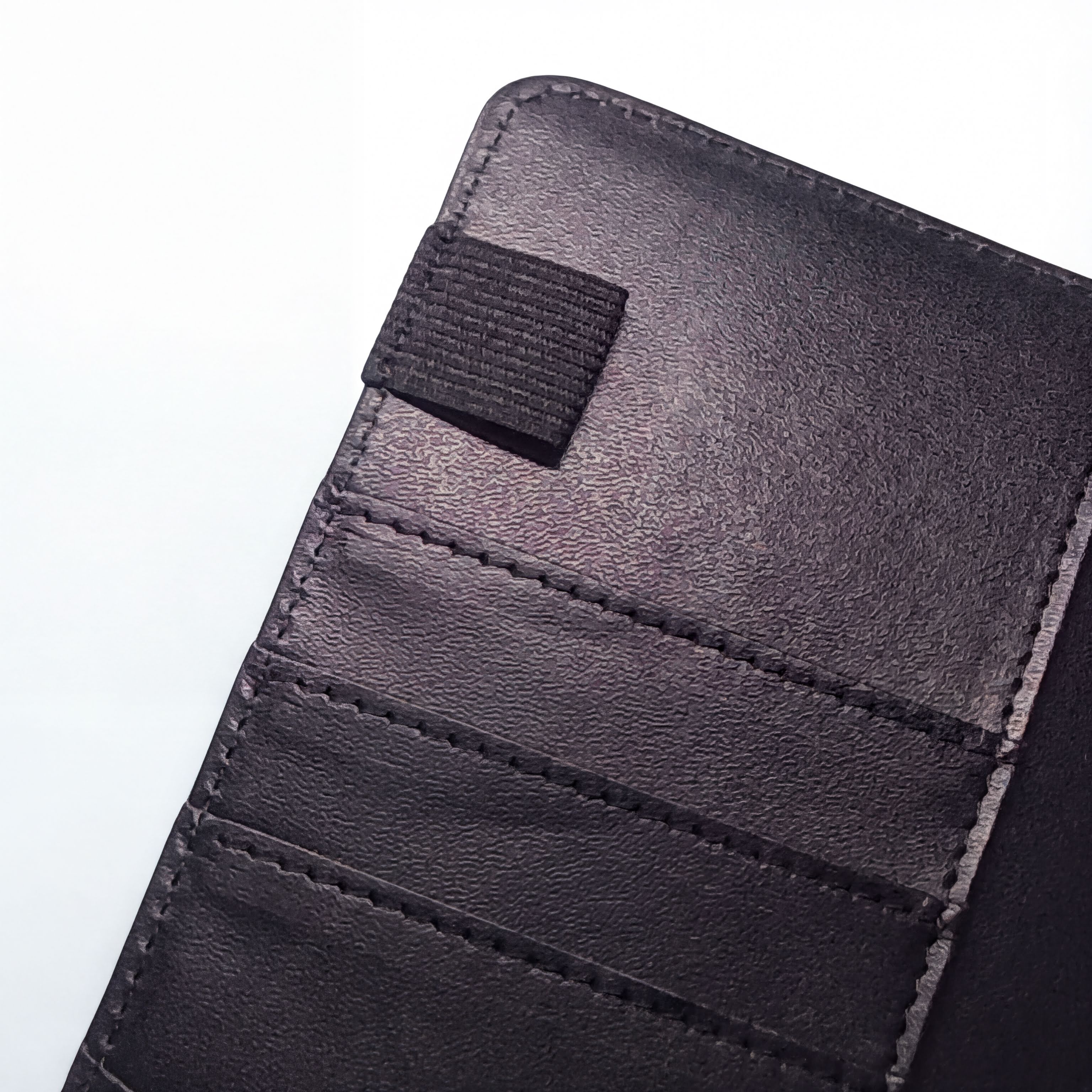 Black leather wallet with card slots and snap closure, textured surface, precise stitching