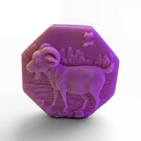 a purple soap bar with an embossed design of a goat on it.