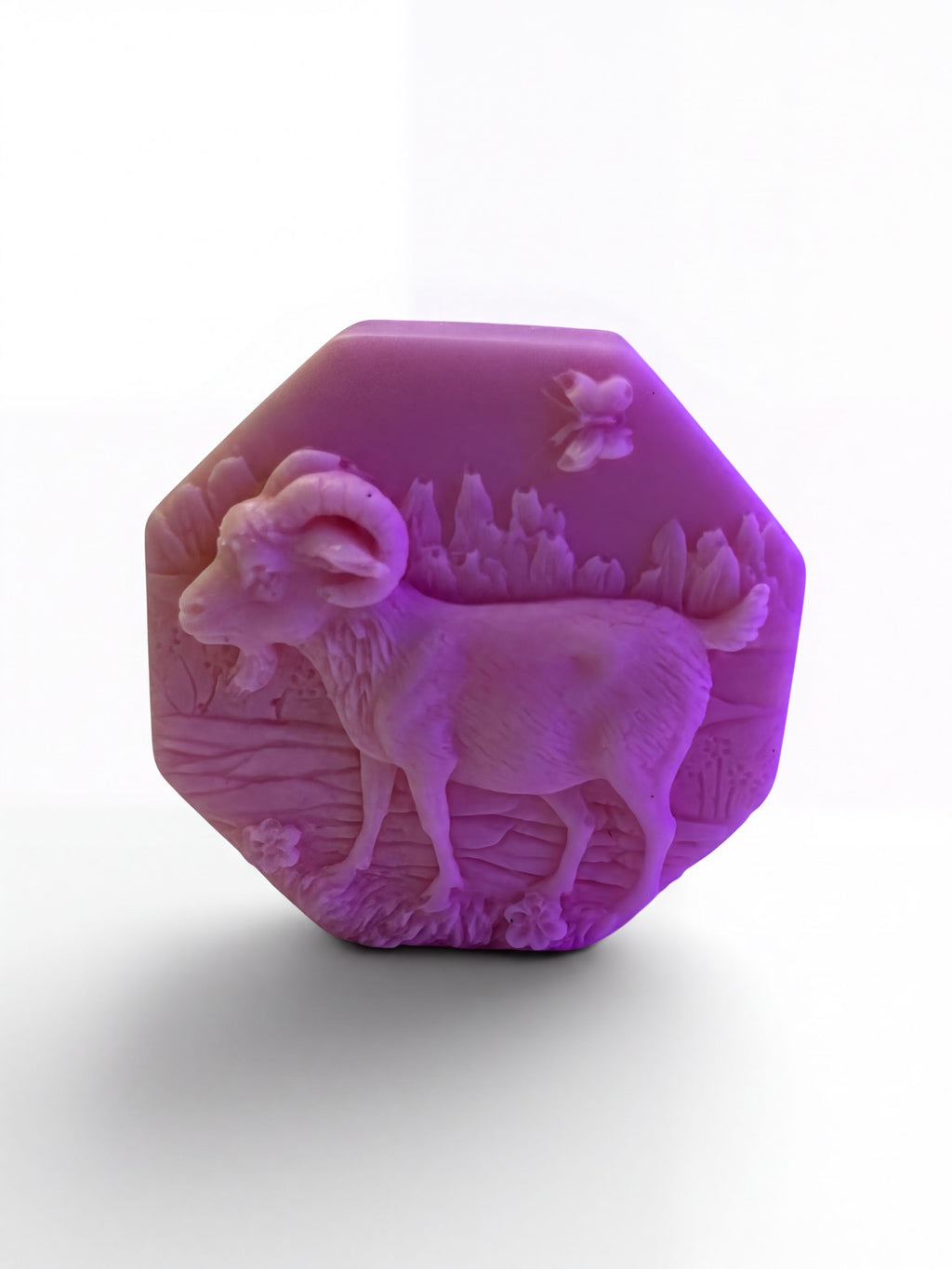 a purple soap bar with an embossed design of a goat on it.
