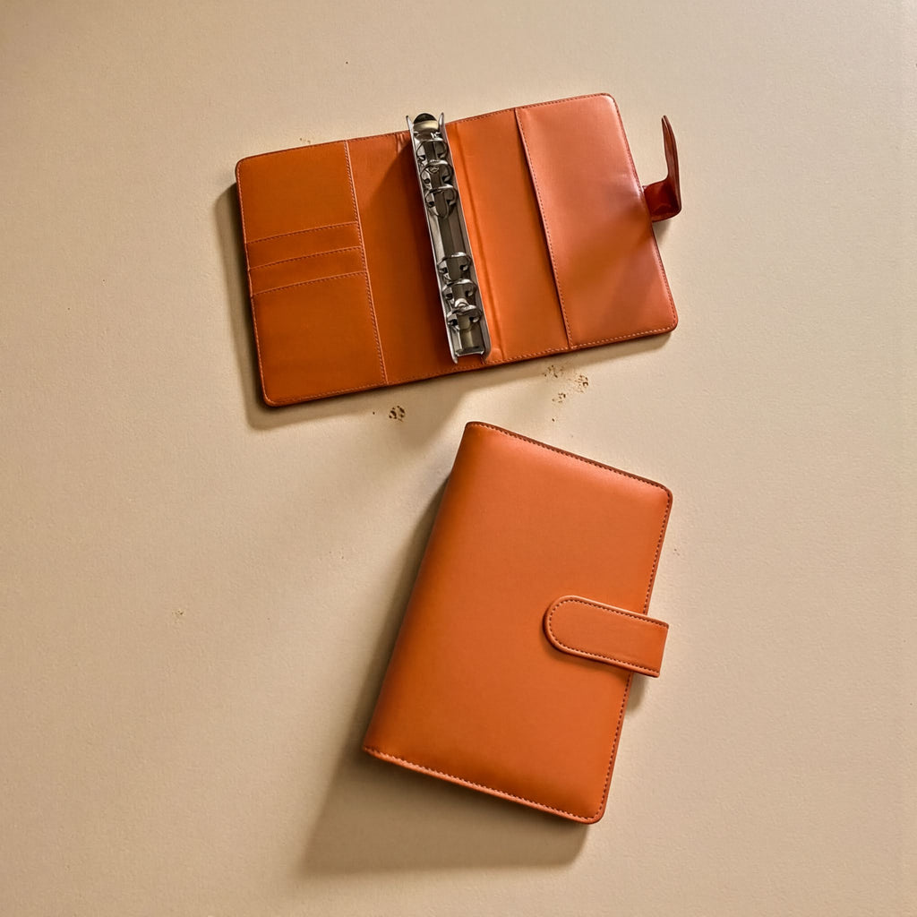 Two leather wallets are placed on a light-colored surface.