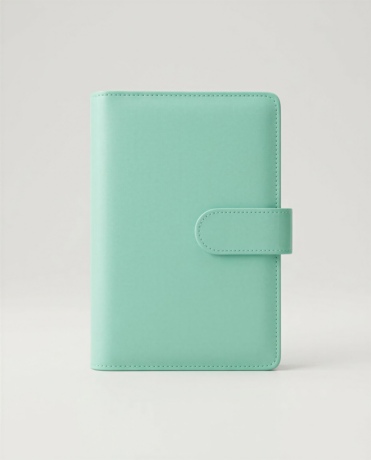 A mint green leather wallet or book cover is shown against a plain white background.