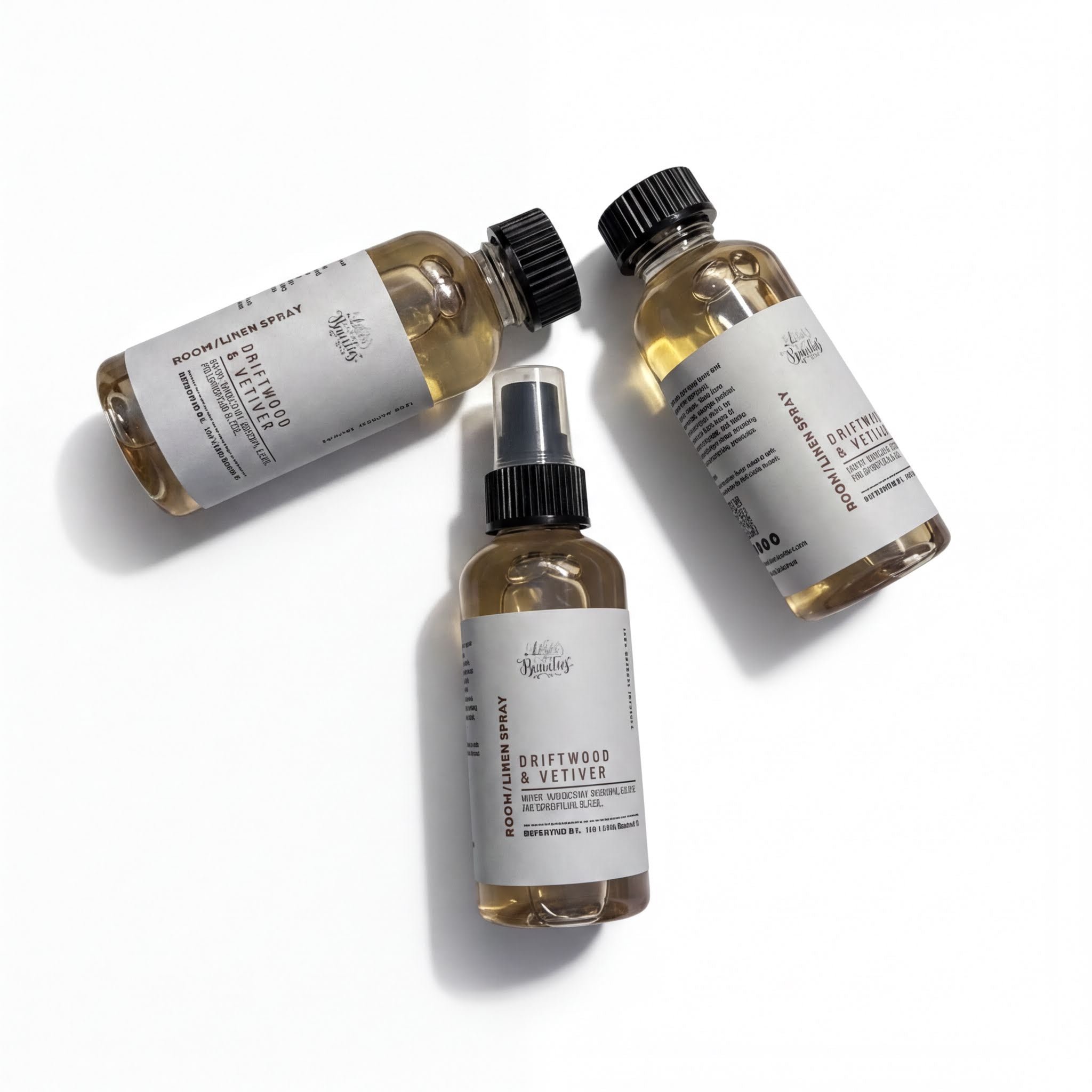 Three bottles of a brown liquid, possibly a hair spray or styling product, are arranged in a triangular formation on a white background.