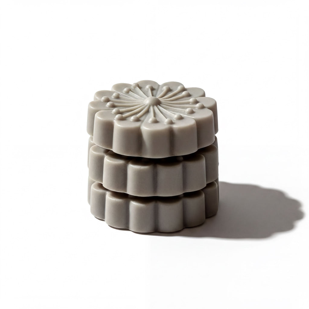 A stack of gray, flower-shaped objects with a decorative design on top.