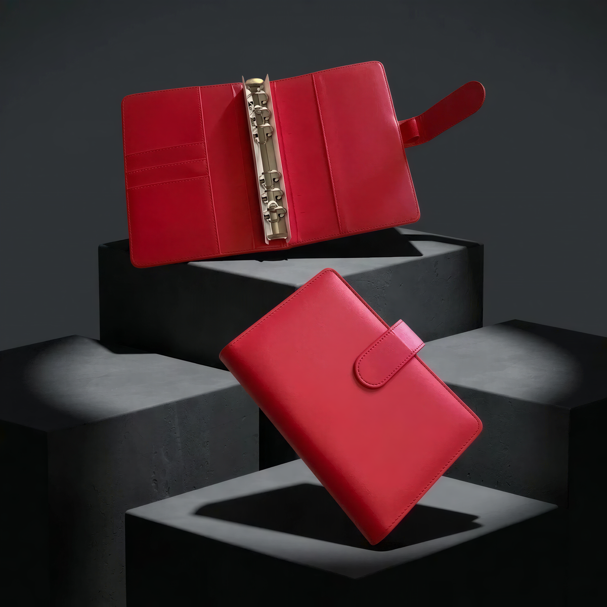 two red leather wallets placed on black platforms against a dark background.