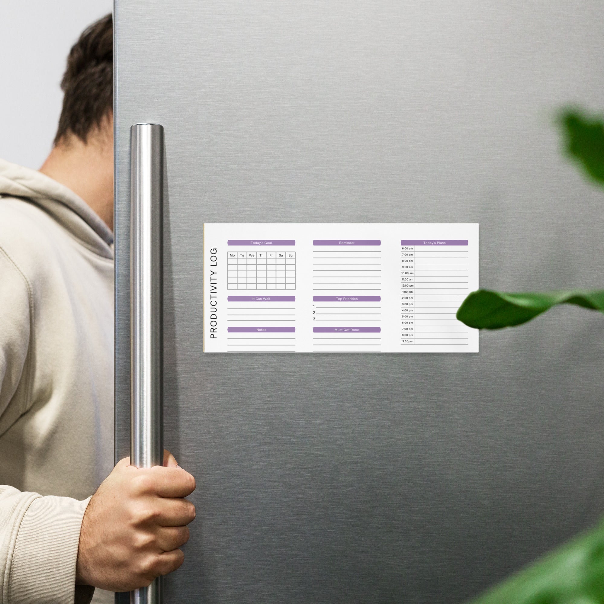 Productivity log planner magnet on stainless steel fridge, helping organize daily goals and tasks with purple headers.